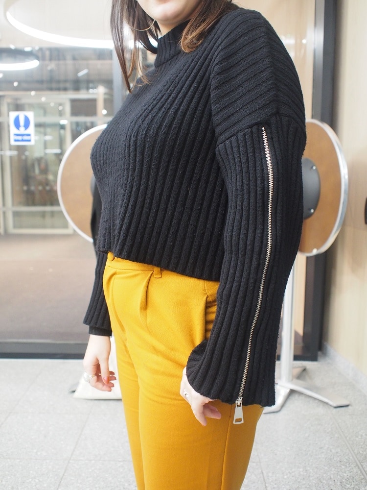 Dina's chunky ribbed crop sweater has silver zippers down the sleeves.
