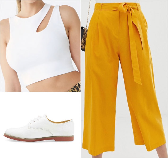 Gemma Chan outfit with mustard yellow trousers, white crop top, white oxfords