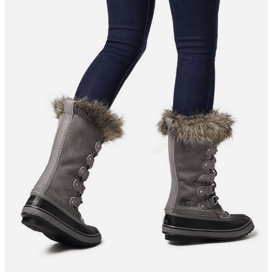 Photo of woman's legs in dark-wash blue skinny jeans and gray and black Sorel Joan of Arctic™ boots